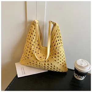 Detailed texture of hand-woven hollow crochet tote bag with light yellow leather shoulder strap