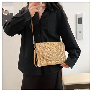 Detailed view of bohemian straw envelope bag with layered semicircular weaving patterns