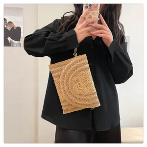 Close-up of bohemian straw envelope bag featuring a unique spiral woven pattern on the flap