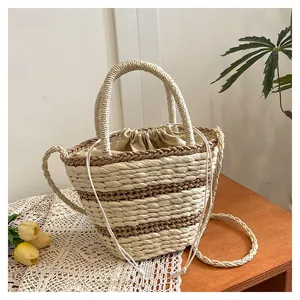 Détail du sac seau tressé avec texture en paille rayée et fermeture à cordon sécurisée