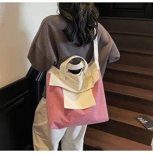 Red gingham tote bag detail showing canvas front pocket and wide handles for commute