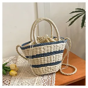 Détail du sac seau tissé à rayures avec fermeture à cordon et poignées confortables