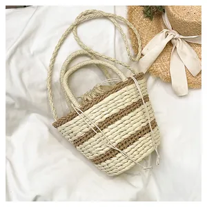 Vue détaillée d'un sac seau en paille tissée avec motif rayé et doublure à cordon