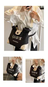 Detail of canvas tote with embroidery, braided handle and adjustable shoulder strap