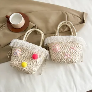 Handgemaakte zomerse strooien handtas met pompons en kant in een stijlvol vierkant model