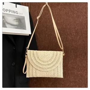 Detail of bohemian straw clutch featuring layered wave-patterned flap and woven texture