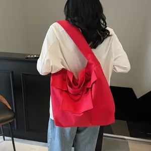 Red high-capacity canvas tote bag with shoulder strap and side pleat detail