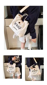 Detail of off-white canvas tote showing WWSJ embroidery and braided handle texture