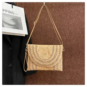 Detail of woven straw envelope bag featuring tiered semicircular texture and gold hardware