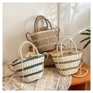 Détail de sacs seaux en paille tressée en trois tailles avec doublure à cordon