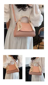 Detail of pink woven leather handbag with printed silk scarf handle and FASHION logo