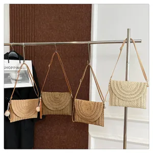 Detail of woven straw envelope bags in four colors with refined textures and shoulder straps