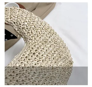 Close-up of beige woven straw handbag showing intricate texture and circular handle detail