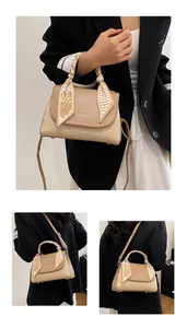 Detail of khaki leather handbag with woven texture, silk scarf handle, and fashion text