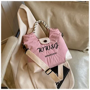 Detail of pink and beige patchwork tote bag with WWSJ logo and woven handle texture