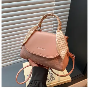 Pink patchwork handbag with woven texture detail and scarf wrapped handle decoration