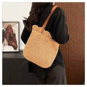 Detail einer hohl gewebten Stroh-Schultertasche mit Wellenrand und Lederriemen