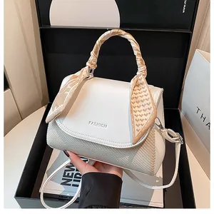 Detailed shot of textured woven bag with silk scarf handle and elegant fashion text