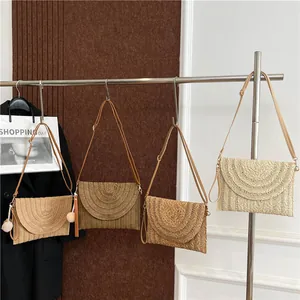 Bohemian woven straw envelope bag with semi-circular pattern and long crossbody strap