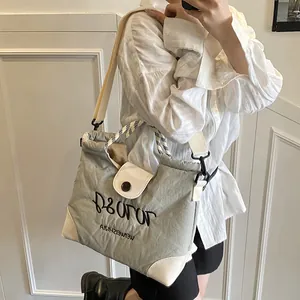 Grey canvas tote bag with white leather trim and brand embroidery for women