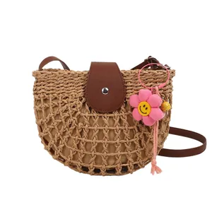 Franse retro halfronde strooien zadeltas met bruine leren riem en bloem hanger