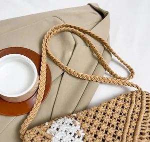 Detail showing the braided shoulder strap and woven texture of the straw crossbody bag