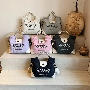 Quilted tote bags in six colors with woven rope handles on a stone display