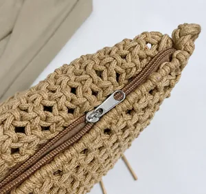 Macro shot of smooth metal zipper detail on bohemian woven straw shoulder bag