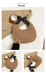 Detail view of khaki straw bag with polka dot bow handle on a stylish blazer background