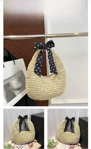 Detailed view of handmade beige straw handbag featuring a polka dot silk bow decoration