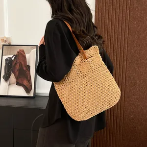 Modische ausgehöhlte Stroh-Schultertasche mit braunem Lederriemen und Nietendetails