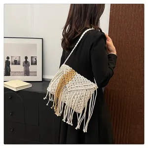 Detail of bohemian straw bag with two-tone fringe tassels and twisted rope strap