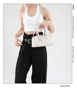 Detail view of stylish cream Boston bag with fashion logo and adjustable shoulder strap