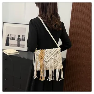 Detail of bohemian straw bag with fringe tassels and woven V-shaped pattern textures