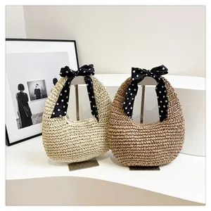 Detailed view of woven straw handbags featuring decorative polka dot silk scarf handles
