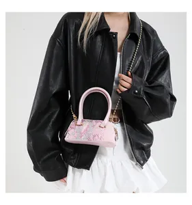Pink sequin shell bag with a gold chain strap shown on a model in a trendy outfit