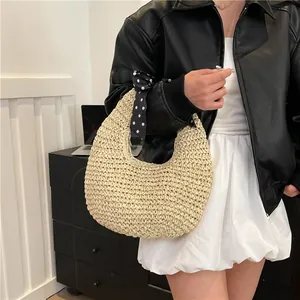 Handmade straw hobo bag with polka dot scarf detail and natural fiber weaving