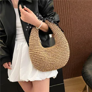 Straw hobo shoulder bag with polka dot scarf detail worn by a model in a trendy outfit