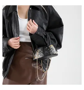 Detail view of mini shell bag with gold chain strap and textured sequin finish