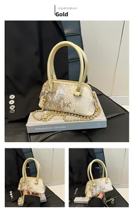 Close-up of gold shell bag featuring metallic snake skin texture and chain strap