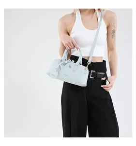 Detail of light blue crossbody tote bag showing pebble leather texture and FASHION logo