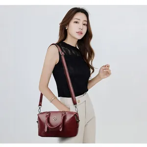 Chic burgundy soft leather boston handbag with metallic logo for stylish women