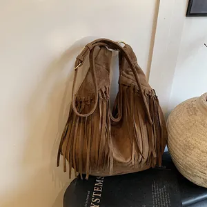 Brown bohemian suede hobo bag with long fringe tassels and golden hardware rings