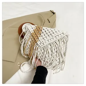 Detail of bohemian woven crossbody bag featuring dual-tone fringe and handmade textures