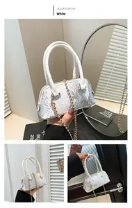 Detail of white snakeskin texture shell bag with gold chain strap and top handle