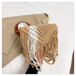 Detail of bohemian straw crossbody bag featuring handmade fringe and woven textures