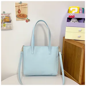 Detalle de bolso tote azul claro en cuero sintético mate con correa ajustable