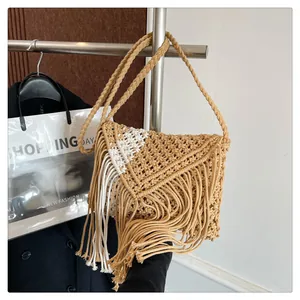 Detailed view of bohemian straw woven bag featuring handcrafted fringe and crossbody strap