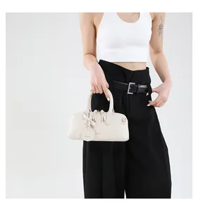 Close-up of cream-white Boston bag with litchi grain texture and tassel double zippers