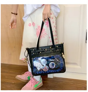 Detalle del bolso tote de cuero negro con ventana transparente y encaje azul